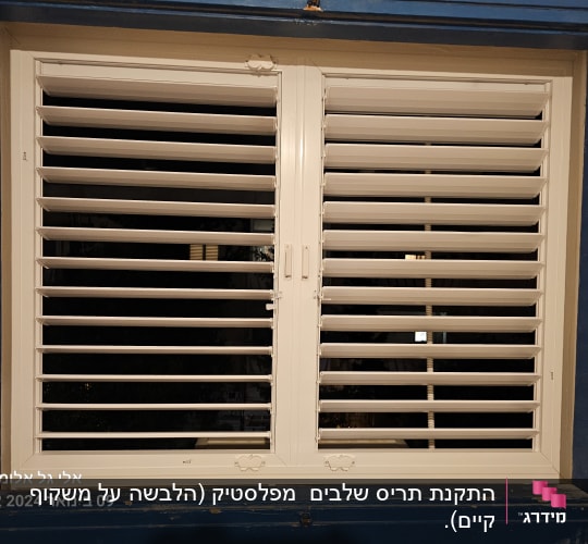 תריסי אלומיניום לבנים בחלון